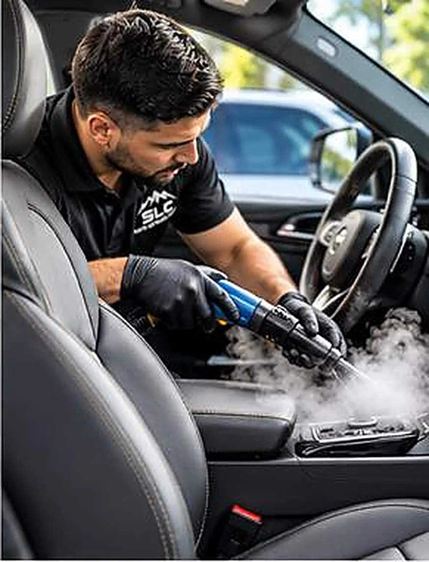 Technician steam cleaning a vehicle interior